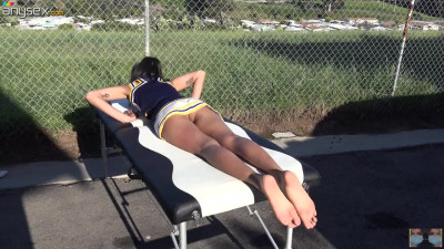 Cheerleader without panties sunbathing on the massage table